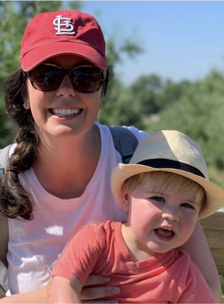 Mom holding toddler both wearing hats