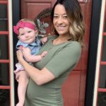 Pregnant Mom holding happy well rested baby overland park kansas